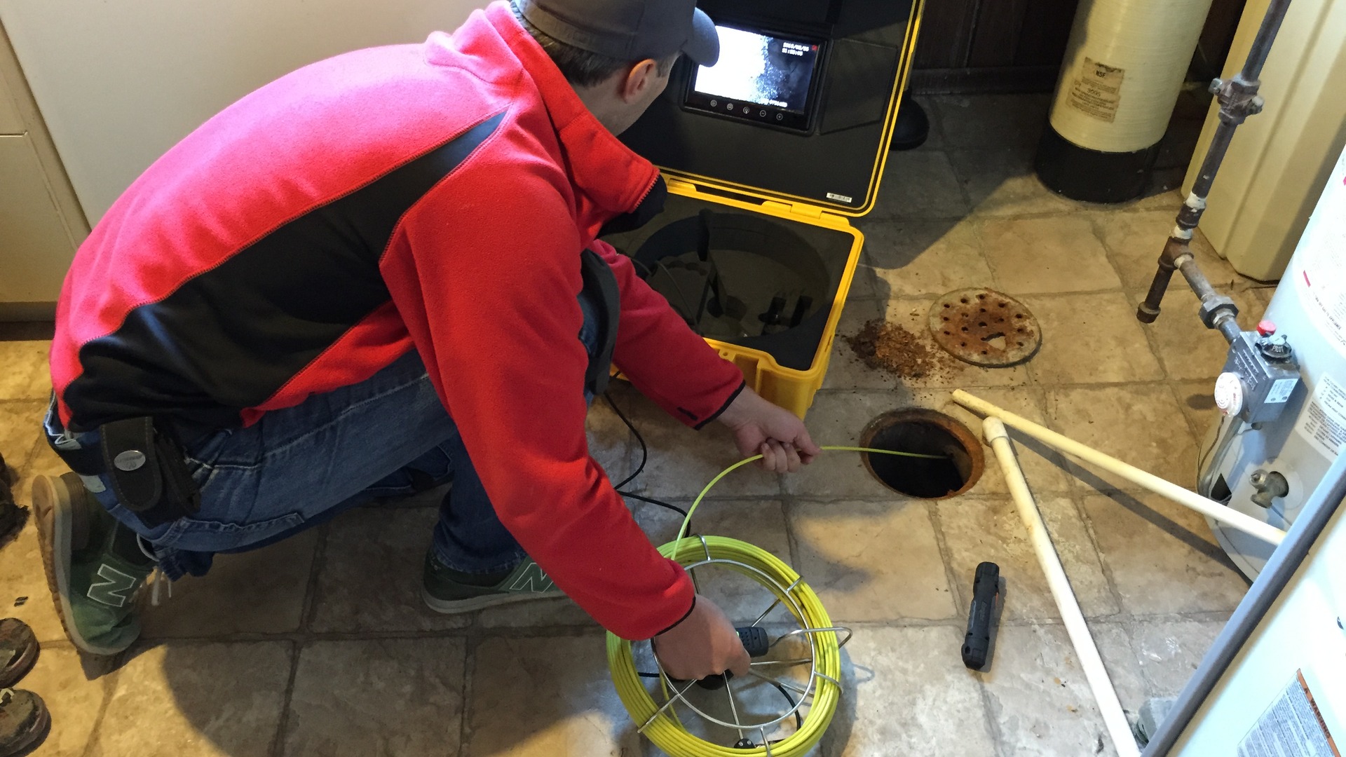 Residential sewer camera reel and monitor on a tile floor